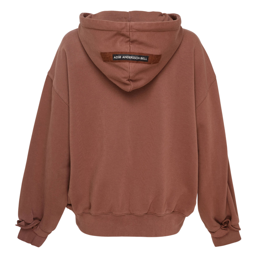 Andersson Bell Raw-Cut Studded Zip-Up Hoodie in dark brown with tonal collegiate embroidery, gunmetal-studded raw-cut pockets, and tie-detail cuffs