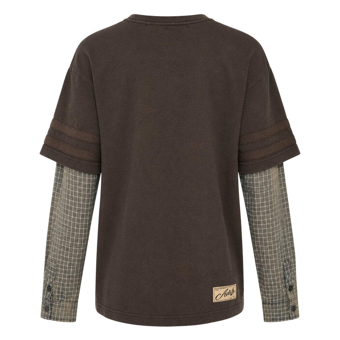 Andersson Bell Layered Sleeve Graphic Tee in washed dark jersey with tonal chest graphic print and green plaid shirting underlayer sleeves, shot flat on white background