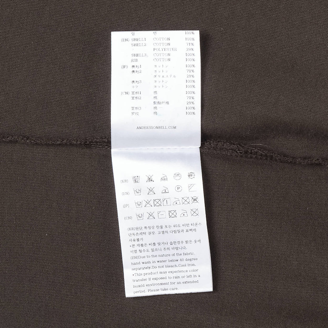 Andersson Bell Layered Sleeve Graphic Tee in washed dark jersey with tonal chest graphic print and green plaid shirting underlayer sleeves, shot flat on white background