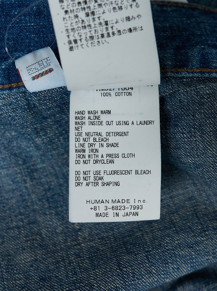 Human Made baggy denim pants in washed mid-blue with oversized patch pockets and a heart logo print on the leg, shown from the front - view 3