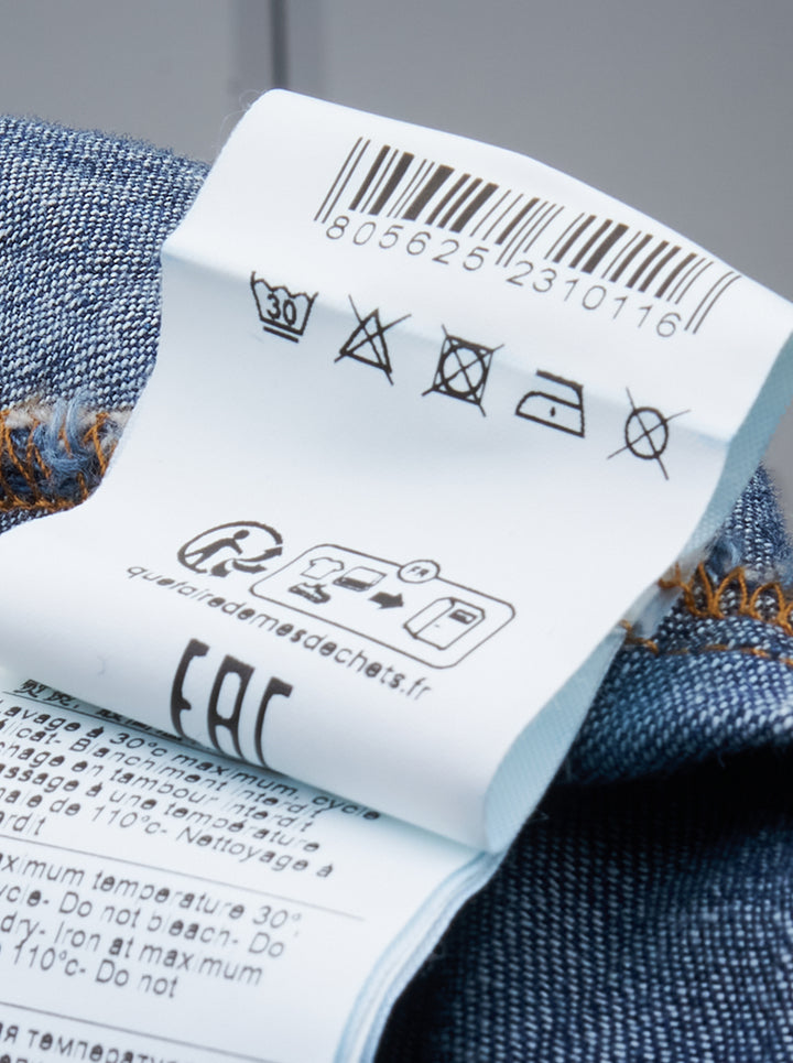 MSGM indigo denim blouse with sculptural attached bowtie bib, button-down collar, full button placket, and wide double cuffs, displayed flat on a white background - view 3