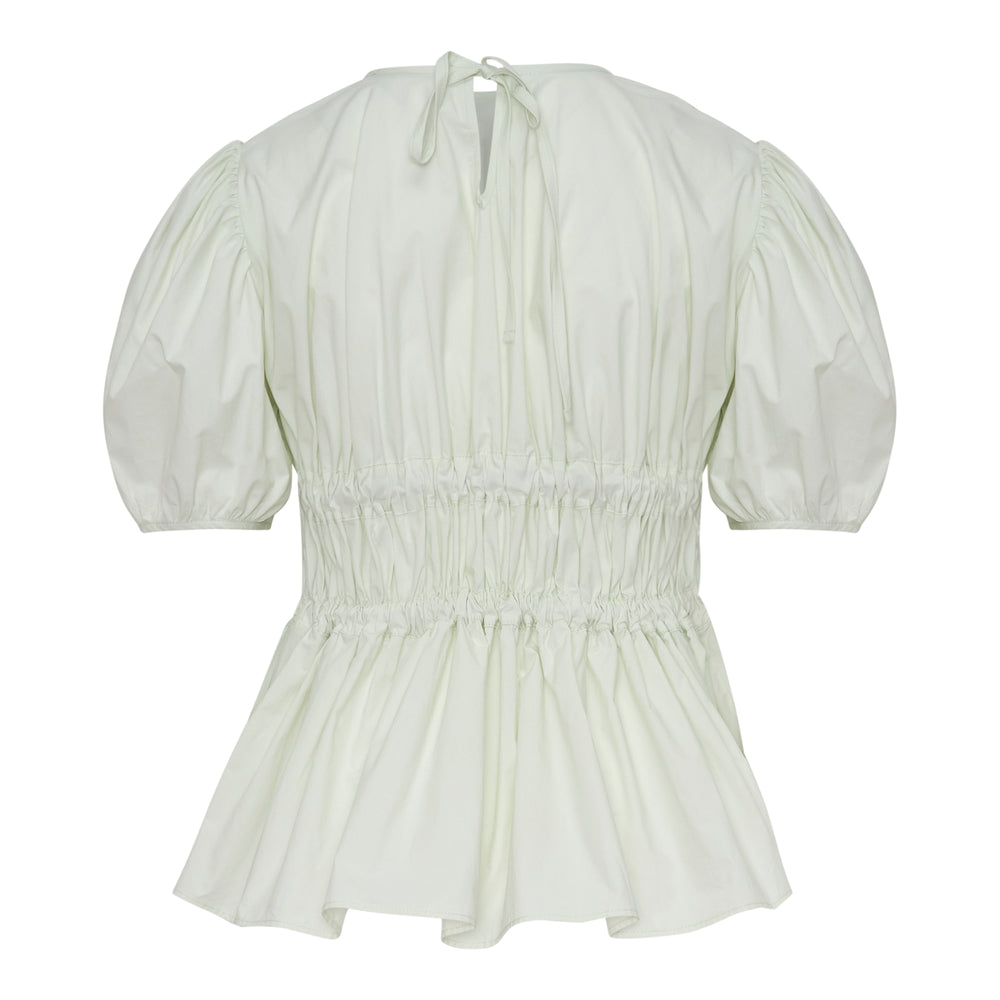 Cecilie Bahnsen Freya Cotton Peplum Top in mint, rear view showing puff sleeves, smocked waist with grosgrain ribbon bows, keyhole back tie, and flared peplum hem