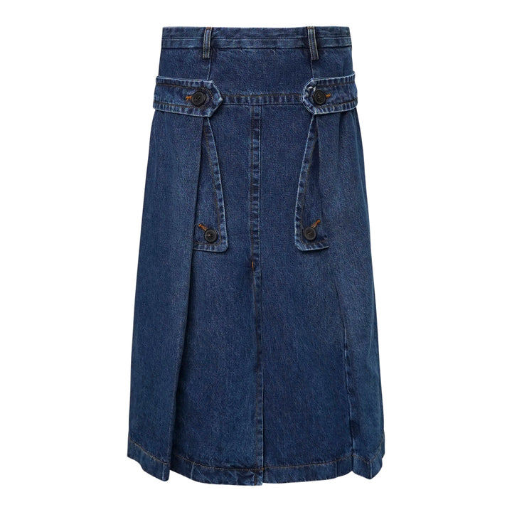Dries Van Noten indigo wash denim midi skirt with buttoned flap pockets, inverted pleats, and a structured A-line silhouette, photographed flat on a white background