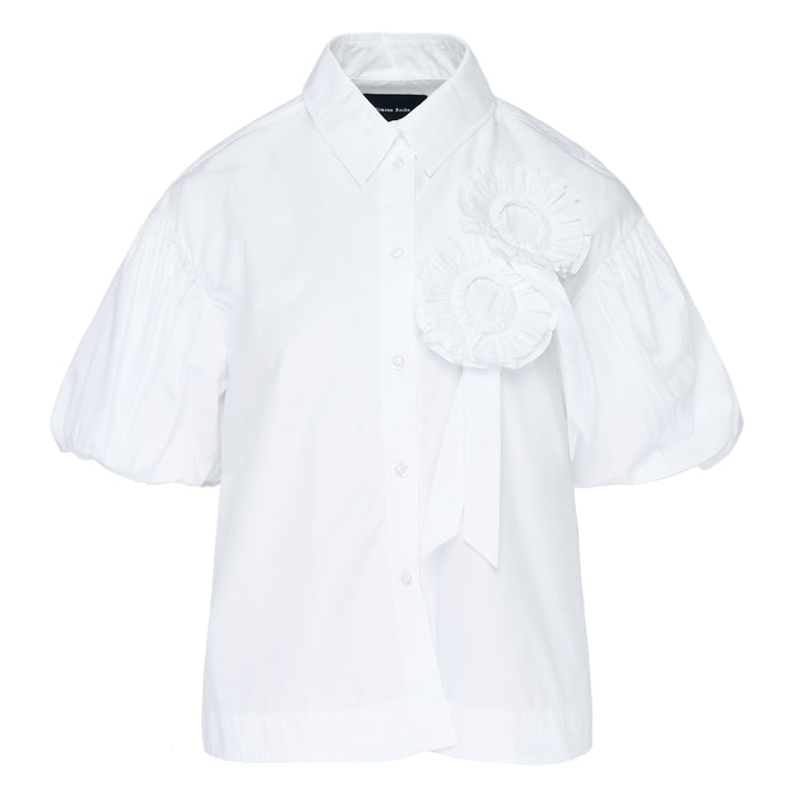 Simone Rocha white cropped blouse with voluminous pleated puff sleeves and an oversized 3D rosette corsage with ribbon detail on the chest