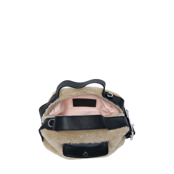 Simone Rocha Mini Faux Fur Biker Bag in neutral tan with black leather handles, front snap-closure pocket, and adjustable crossbody strap with silver-tone hardware