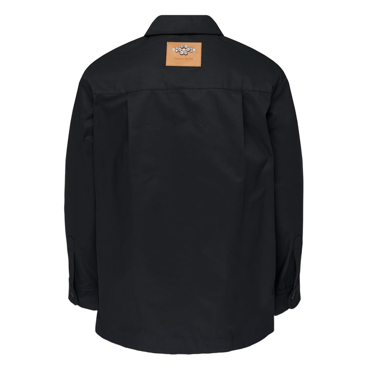 Simone Rocha black cotton twill military overshirt, front view, featuring dual flap chest pockets, tonal button-front closure, and a relaxed oversized silhouette