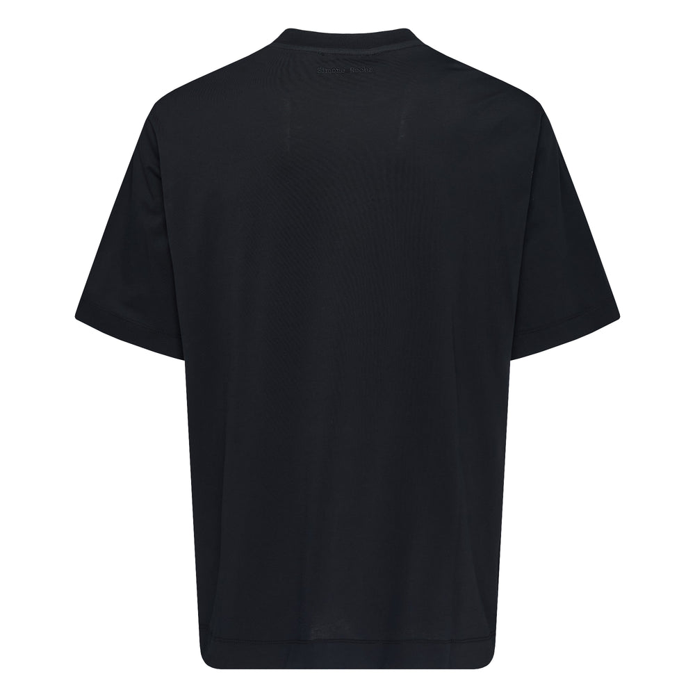 Simone Rocha Ruffle Rosette Boxy Tee in black with two tonal pleated fabric rosettes and trailing ribbon streamers on the chest