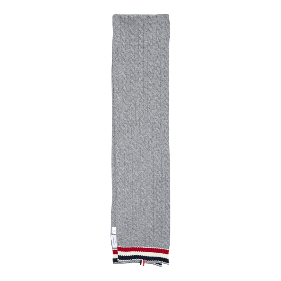 Thom Browne navy cable-knit merino wool scarf with ribbed hem featuring signature red, white, and blue stripe trim and woven brand label tab