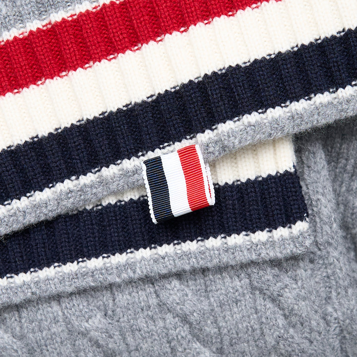 Thom Browne navy cable-knit merino wool scarf with ribbed hem featuring signature red, white, and blue stripe trim and woven brand label tab