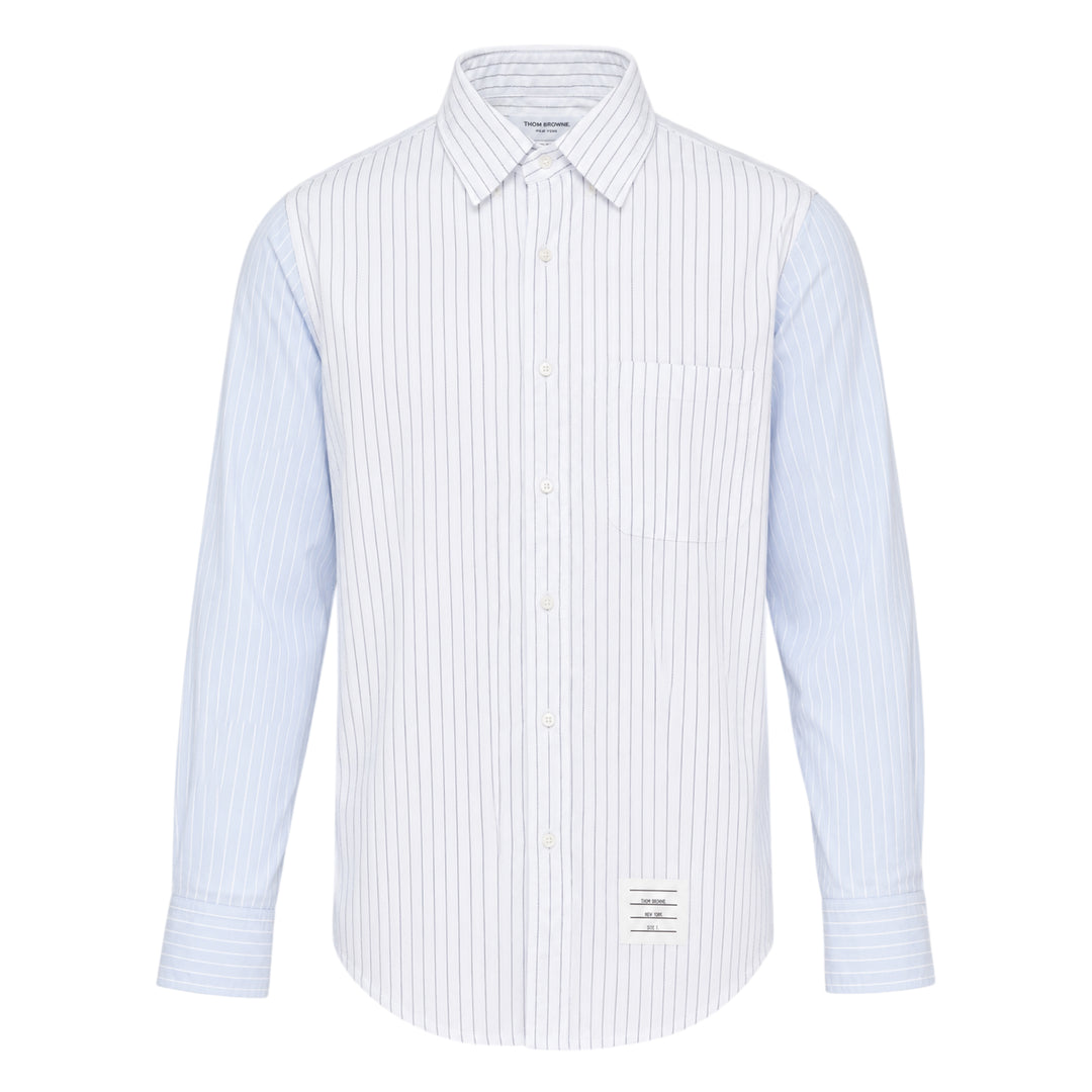 Thom Browne Straight Fit Long Sleeve Shirt in light blue pinstripe with contrast stripe sleeve panels, chest patch pocket, and woven branding label at the hem