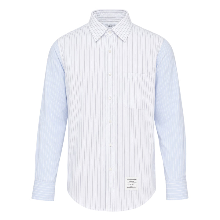 Thom Browne Straight Fit Long Sleeve Shirt in light blue pinstripe with contrast stripe sleeve panels, chest patch pocket, and woven branding label at the hem