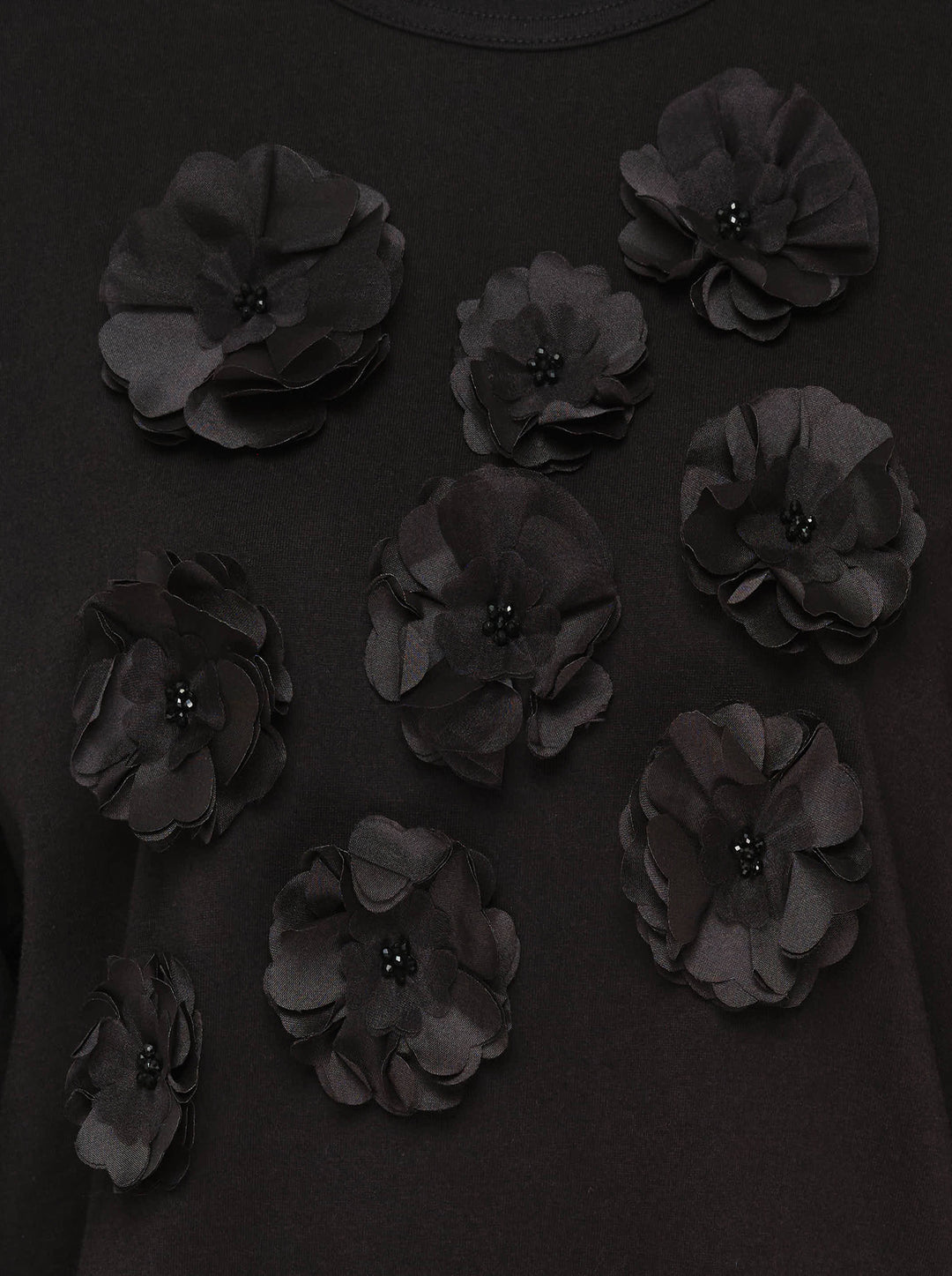 Tao black long sleeve crew neck top with nine tonal satin 3D floral appliqués and bead centres scattered across the chest, shot flat on a white background - view 3
