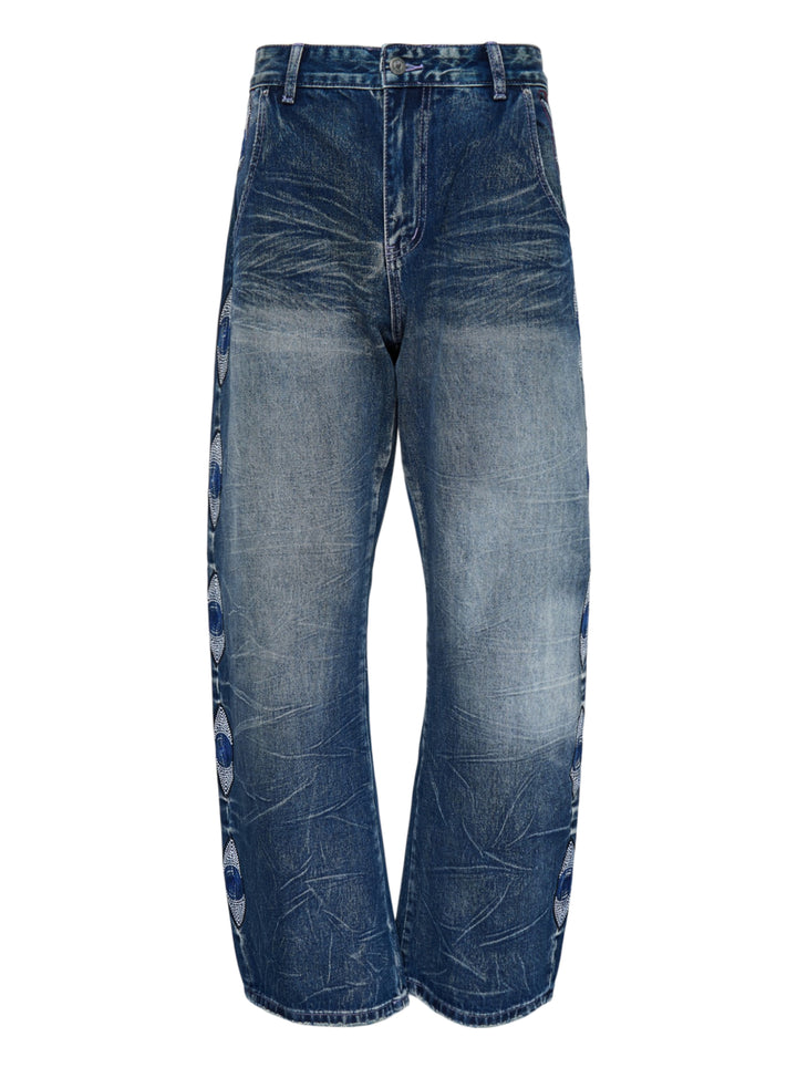 KidSuper Studios Gemstone Eye Embroidery Jeans in faded indigo denim with beaded eye embroidery along both outer legs, shown from the front