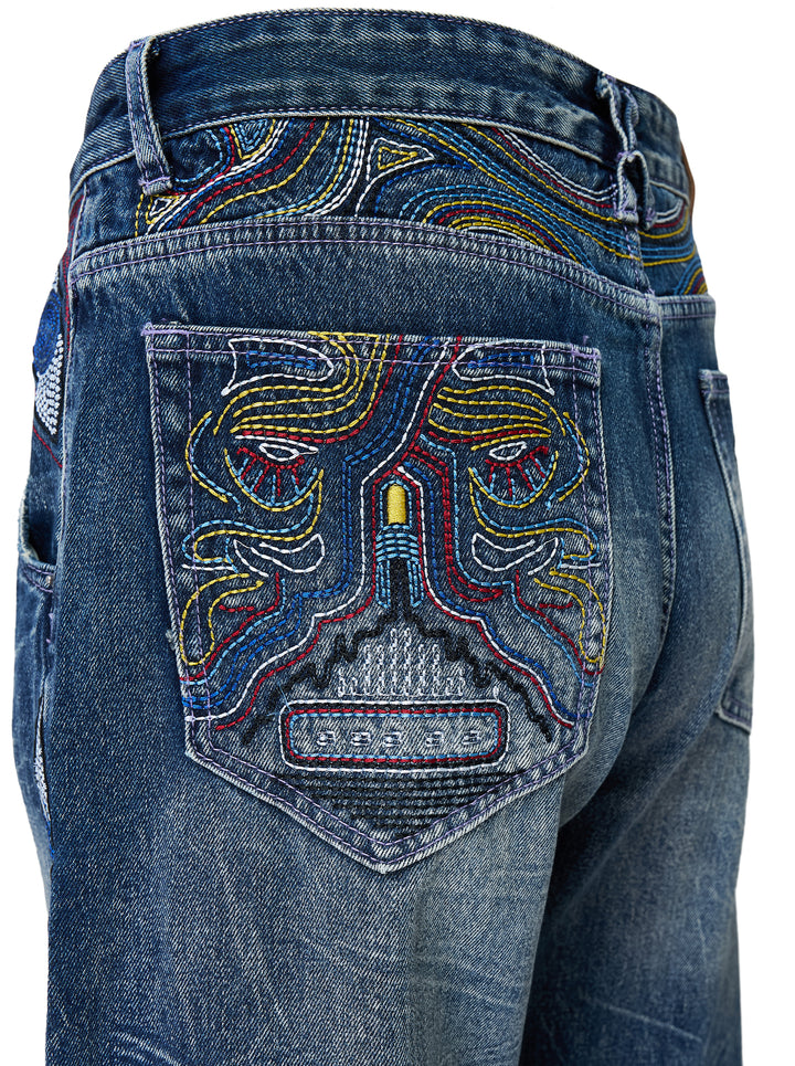 KidSuper Studios Gemstone Eye Embroidery Jeans in faded indigo denim with beaded eye embroidery along both outer legs, shown from the front - view 4