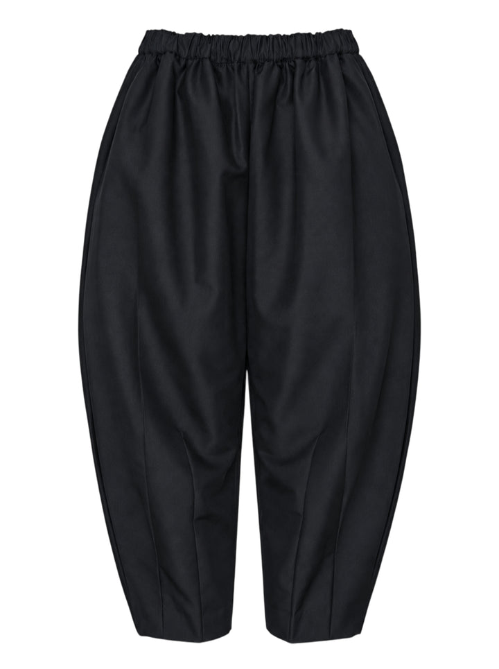 Comme des Garçons black rounded silhouette balloon-leg pants with elasticated waistband and structured vertical seaming, laid flat on white background