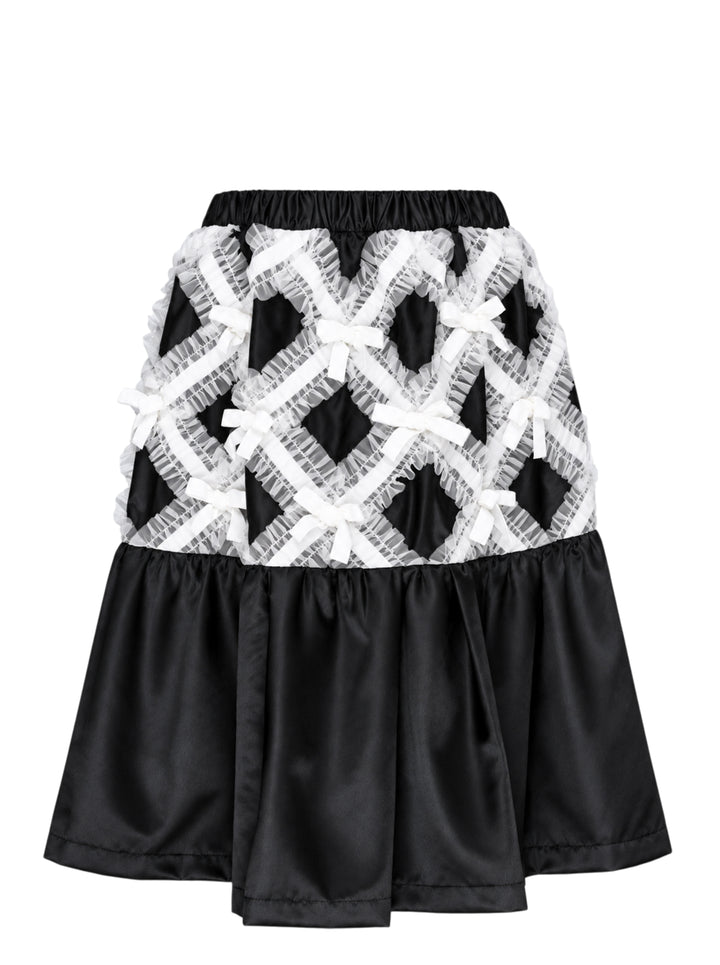 Comme des Garçons Girl black satin A-line skirt with white criss-cross tulle lattice overlay and satin ribbon bows, gathered flared hem, white background