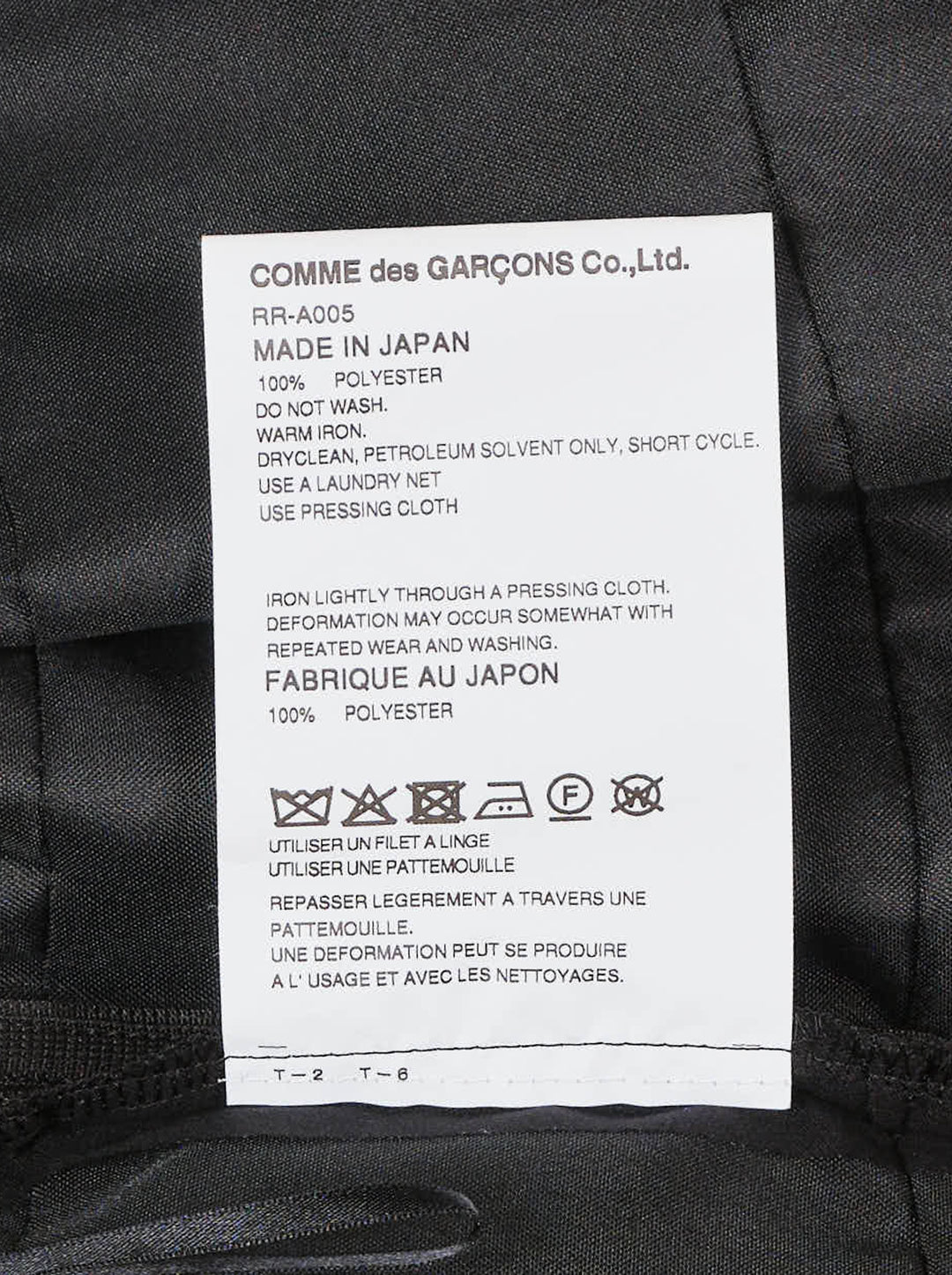 Comme des Garçons Comme des Garçons black crossover pinafore with cascading tiered ruffle skirt and structured waistband, shown from the back against a white background - view 3