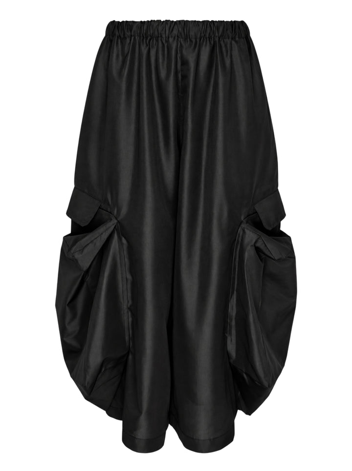 Black wide-leg Comme des Garçons Comme des Garçons pants with an elasticated gathered waist and oversized draped cargo pockets, shown from the front