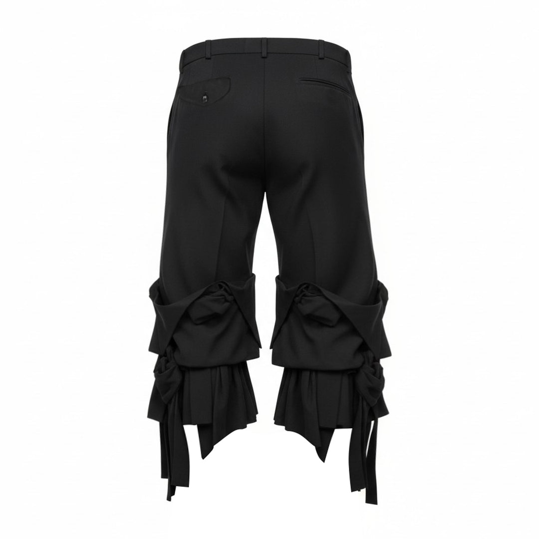 Comme des Garçons Homme Plus black wool tropical wide-leg pants with sculptural knotted bow and cascading ribbon hem trim, front view on white background - view 2