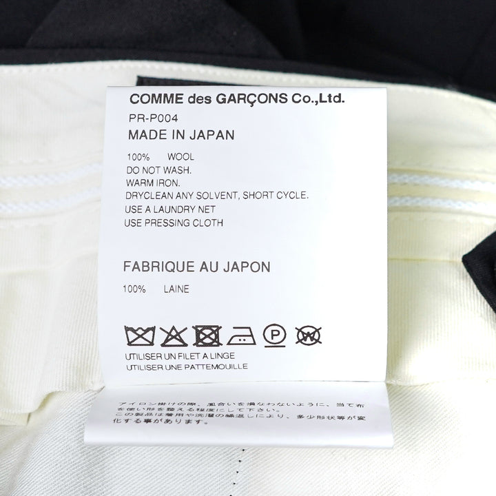 Comme des Garçons Homme Plus black wool tropical wide-leg shorts with cascading ruffle panels on the front, high-rise waistband with belt loops and single button fastening, on a white background - view 3