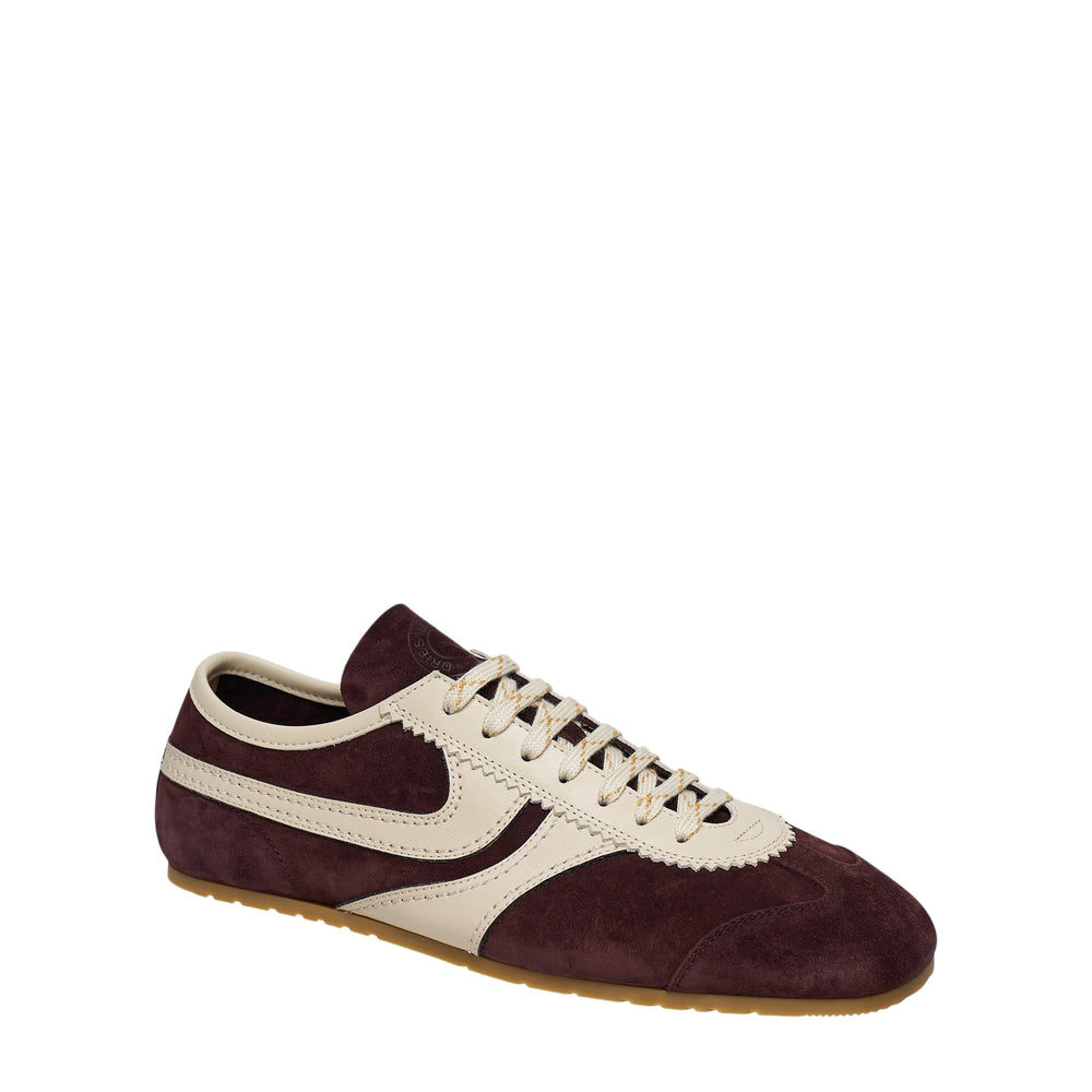 Dries Van Noten slim sneaker in burgundy suede with cream nappa leather overlays, cream laces, and a gum rubber outsole, shown in profile