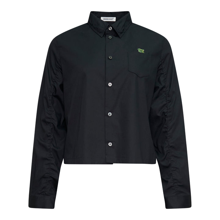 Undercover Cropped U Logo Blouse in black with gathered sleeves, point collar, tonal buttons, and a green embroidered Undercover logo on the chest pocket