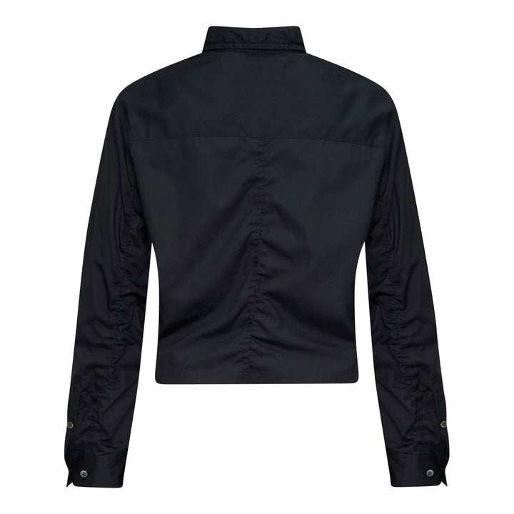 Undercover Cropped U Logo Blouse in black with gathered sleeves, point collar, tonal buttons, and a green embroidered Undercover logo on the chest pocket