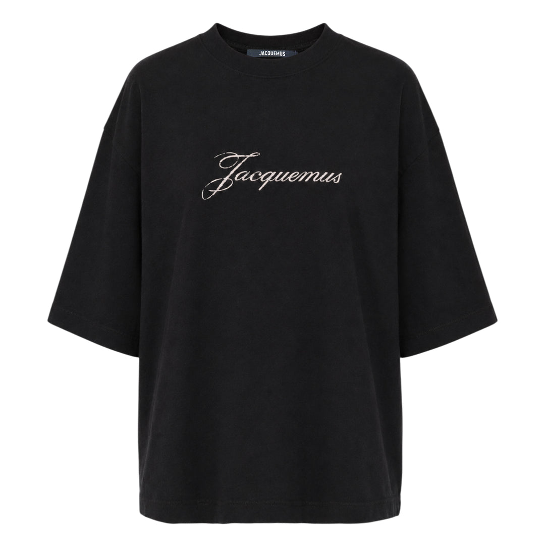 Jacquemus black oversized short-sleeve t-shirt with embroidered cursive logo across the chest and ribbed crew neckline, displayed on a white background