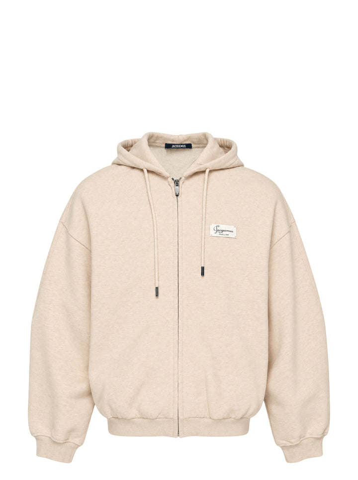 Jacquemus Montaigne oversized zip-up hoodie in beige with drawstring hood, ribbed cuffs and woven chest label