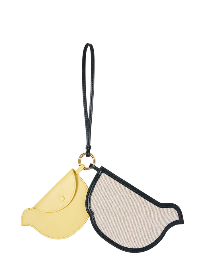 Jacquemus Les Poussins pair of bird-shaped coin pouches, one in yellow leather and one in natural canvas with black trim, hanging from a black leather loop and gold-tone ring
