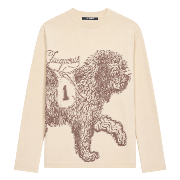Jacquemus Le T-Shirt Bichon in ecru — long-sleeve crew-neck tee featuring a tonal brown hand-drawn curly dog illustration with a varsity number bib and cursive Jacquemus script across the front