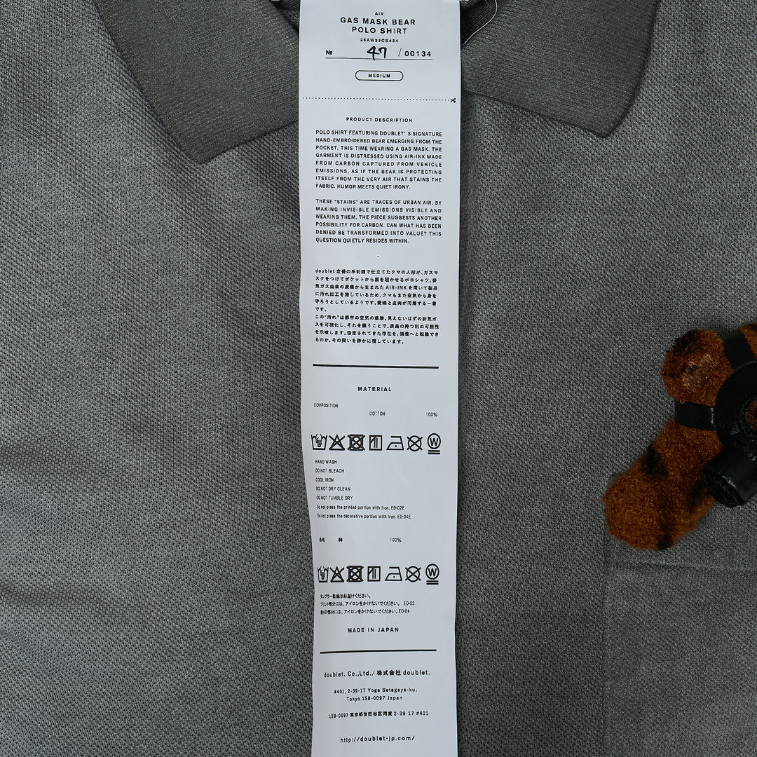 doublet Gas Mask Bear Polo Shirt in dark navy piqué with contrast chambray collar and a miniature Steiff tiger-print teddy bear wearing a gas mask in the chest pocket
