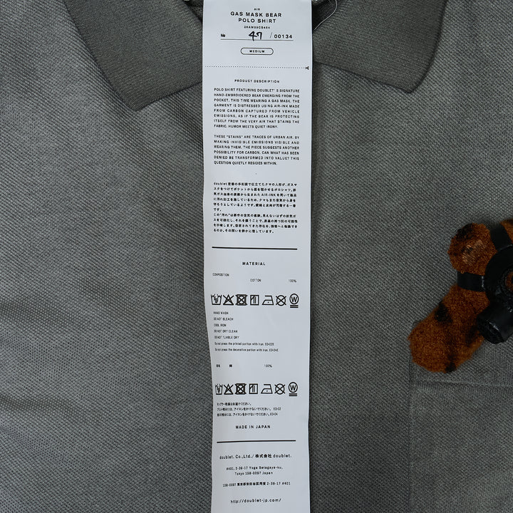 doublet Gas Mask Bear Polo Shirt in dark navy piqué with contrast chambray collar and a miniature Steiff tiger-print teddy bear wearing a gas mask in the chest pocket