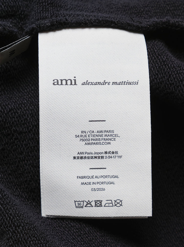 AMI black drawstring sweatpants with ribbed waistband and wide straight leg, shown from the front - view 4