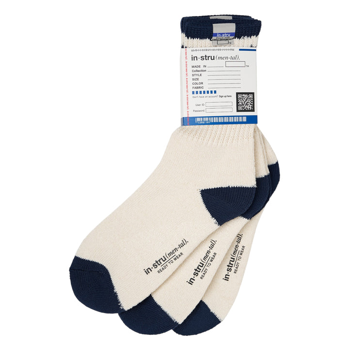 Mihara Yasuhiro three-pack crew socks in off-white with navy contrast cuff, heel, and toe, displayed fanned with branded 'Ready to Wear' sole print visible and original hangtag attached