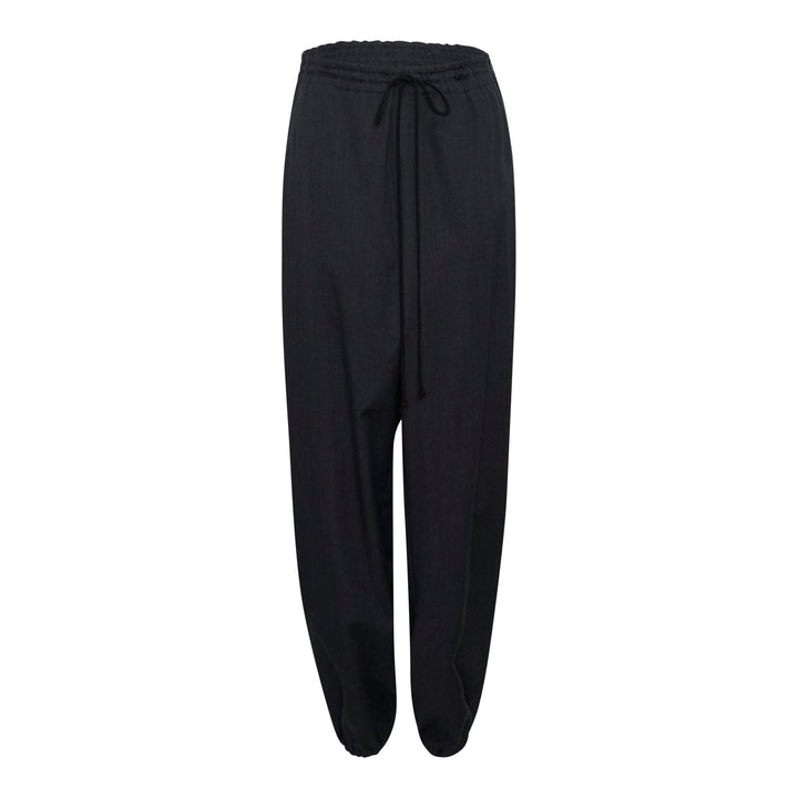 Y's black relaxed-fit drawstring joggers with drop-crotch silhouette, elasticated high-rise waistband with tonal tie, and gathered ankle cuffs, displayed flat on a white background