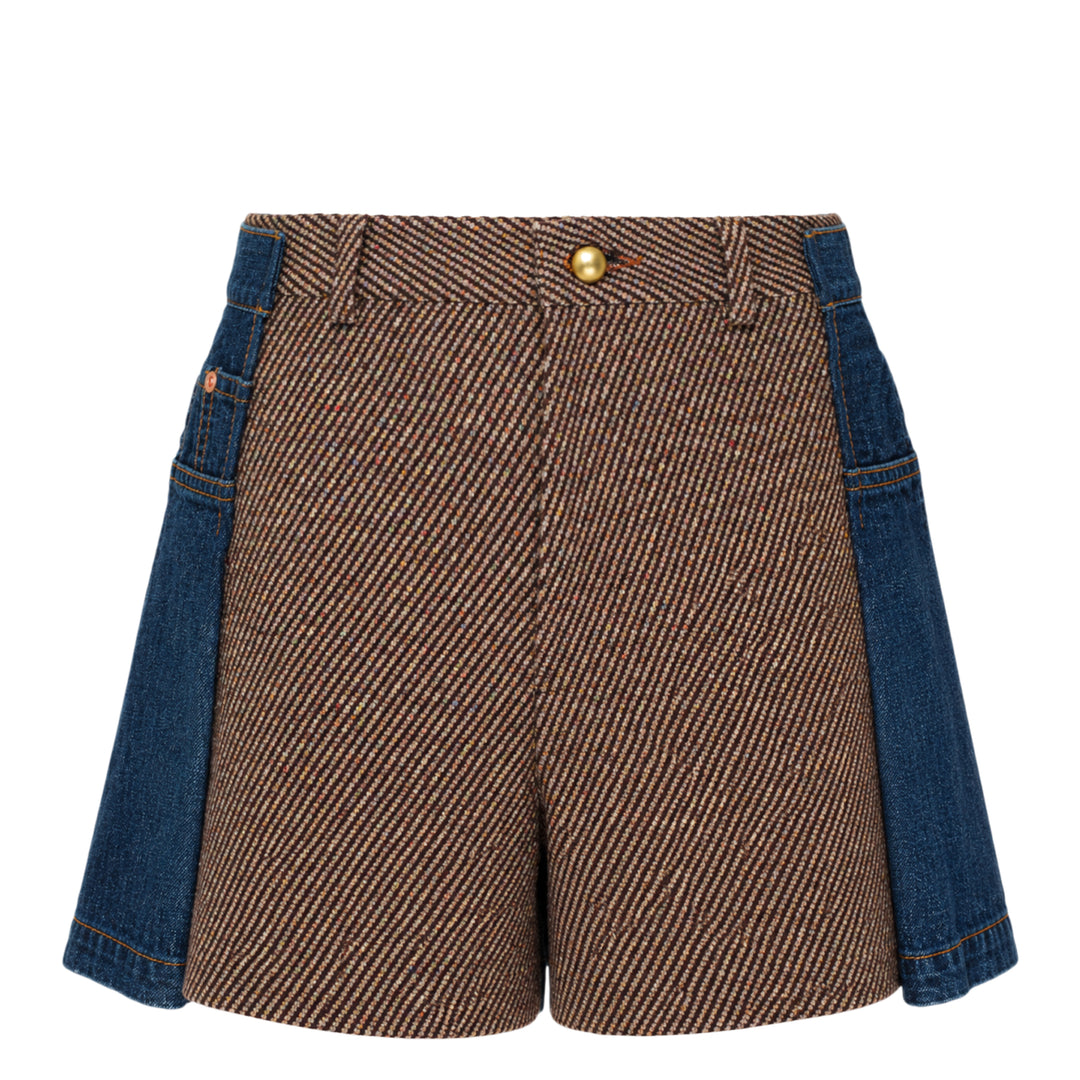 sacai Nep Tweed x Denim Shorts featuring a diagonal herringbone tweed front panel, denim side panels with orange topstitching, and a gold-tone button closure at the high waist