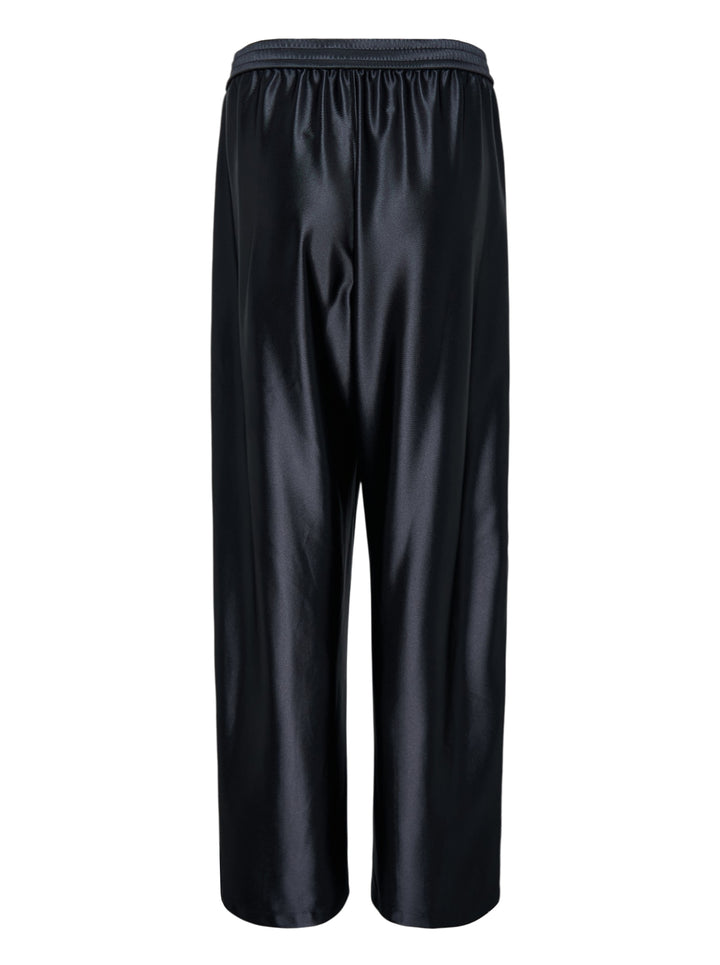 Alexander Wang mid-rise black glossy track pants with embossed side logo panels and elasticated waistband, shown from the front - view 2