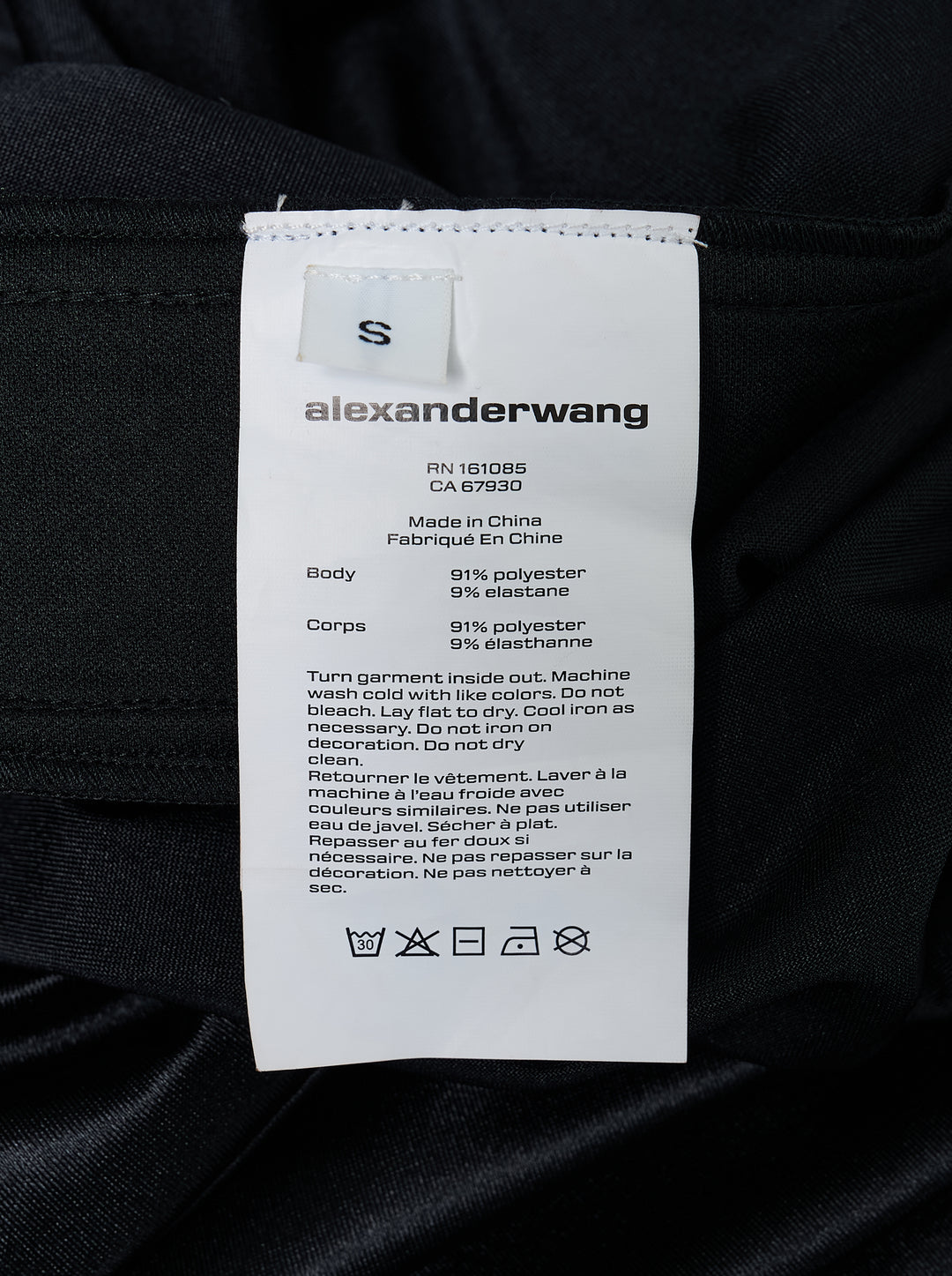 Alexander Wang mid-rise black glossy track pants with embossed side logo panels and elasticated waistband, shown from the front - view 4