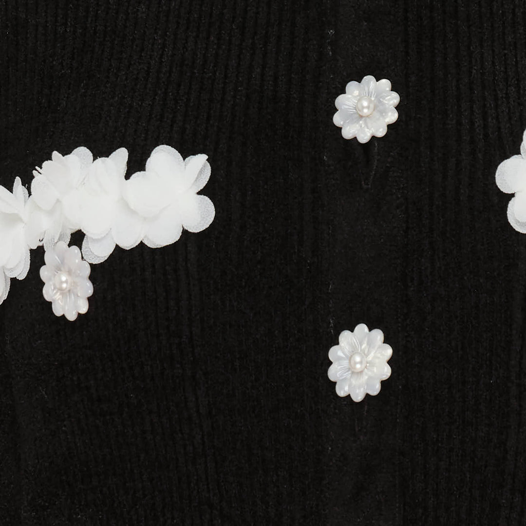 Self-Portrait black chenille ribbed knit mini dress with white floral trim at neckline, cuffs, and patch pockets, daisy button front fastening, fit-and-flare silhouette