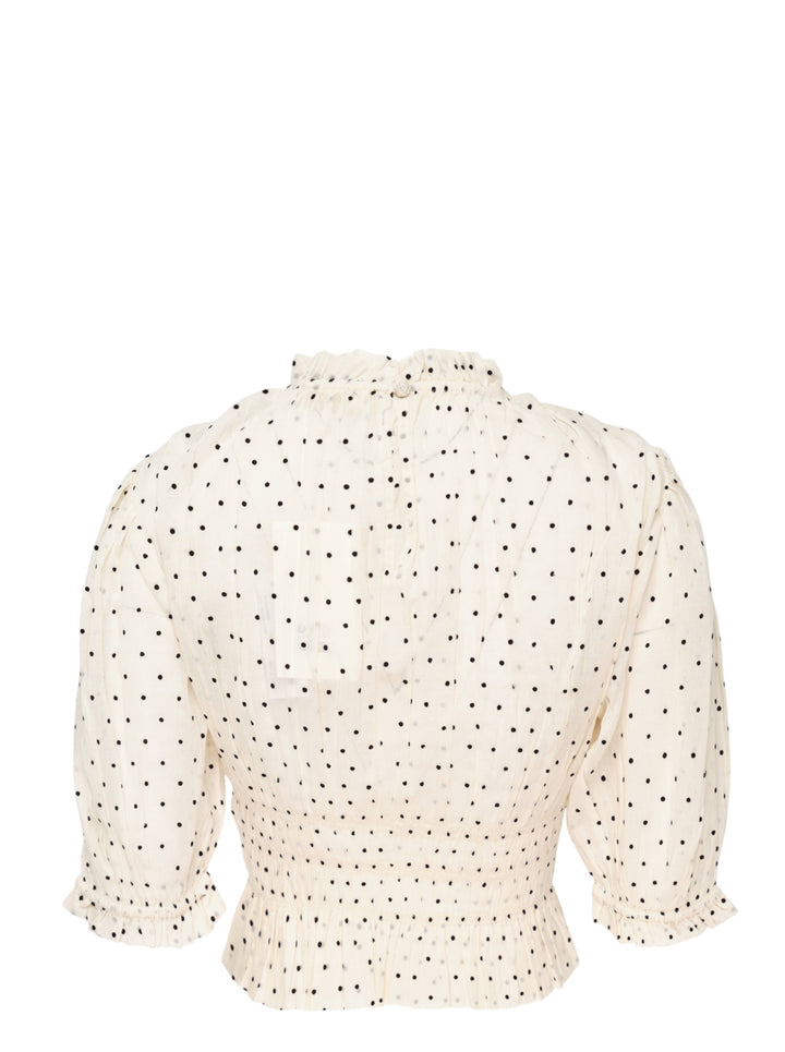 Ulla Johnson Rae short sleeve cotton top in ivory with black polka dots, featuring a ruffled high neckline, puffed sleeves with ruffle cuffs, smocked bodice, and a cropped peplum hem - view 2