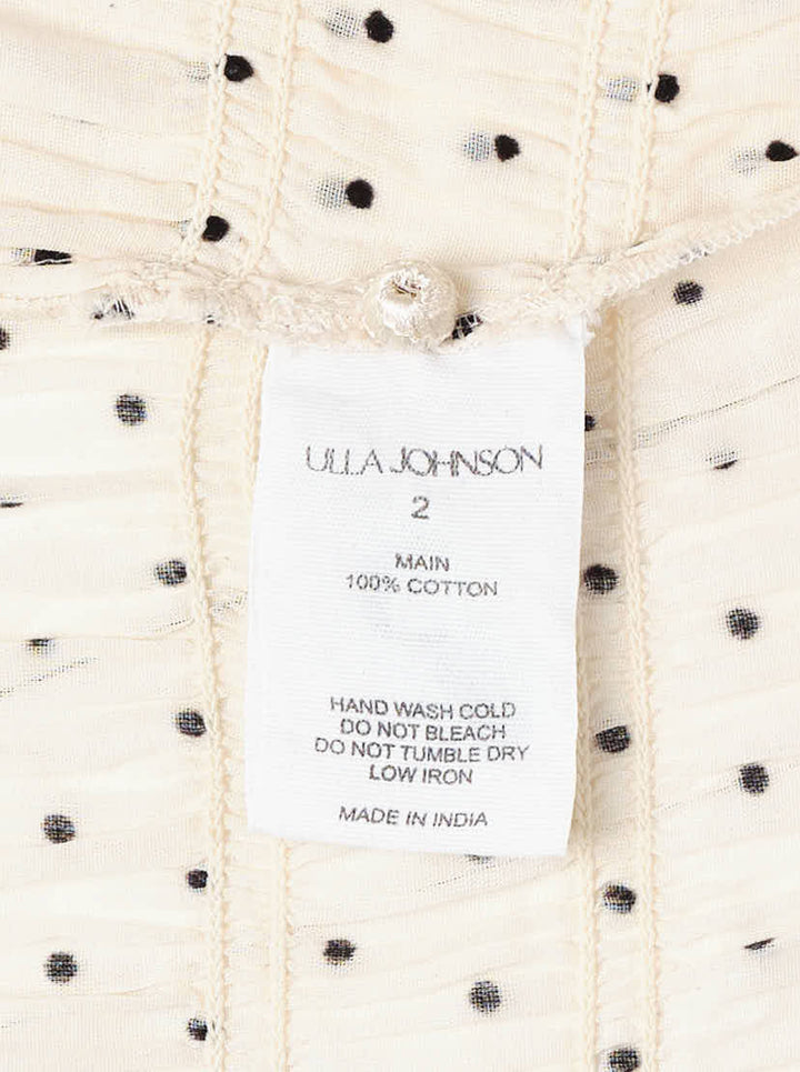 Ulla Johnson Rae short sleeve cotton top in ivory with black polka dots, featuring a ruffled high neckline, puffed sleeves with ruffle cuffs, smocked bodice, and a cropped peplum hem - view 3