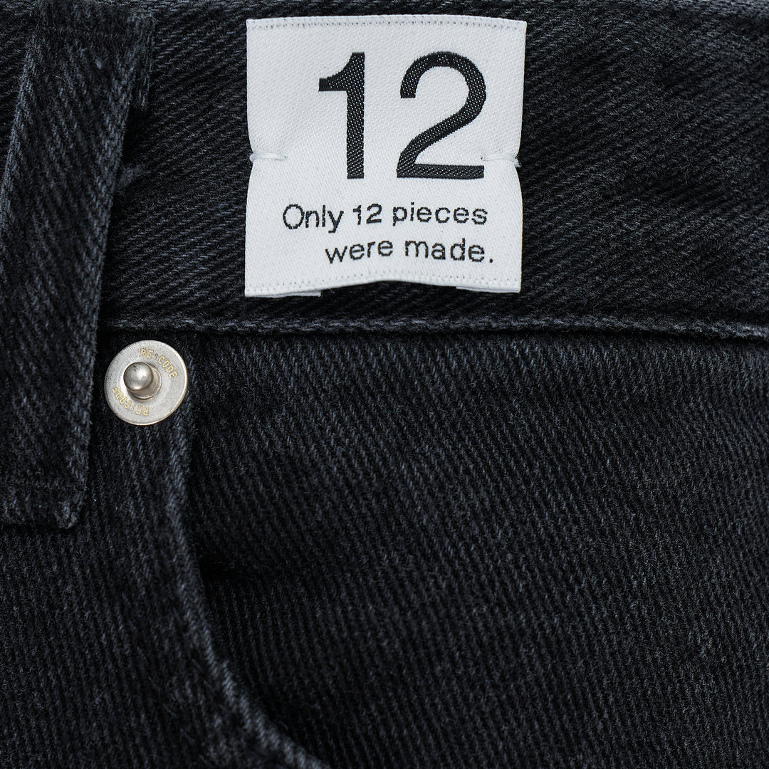 Re;Code Inside-Out Denim Skirt in washed black, midi length with a front slit, raw frayed hem, and five-pocket detailing on a white background