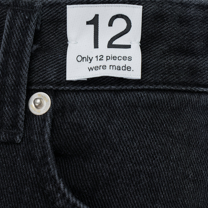 Re;Code Inside-Out Denim Skirt in washed black, midi length with a front slit, raw frayed hem, and five-pocket detailing on a white background