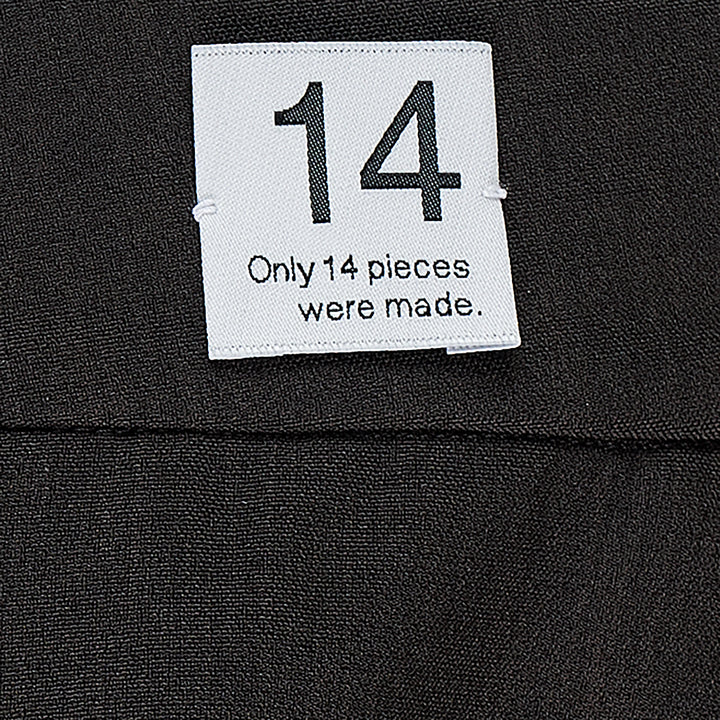 RE;CODE pleated tailored shorts in charcoal, featuring a high waist, double front pleats, wide-leg silhouette, and woven brand label at the waistband
