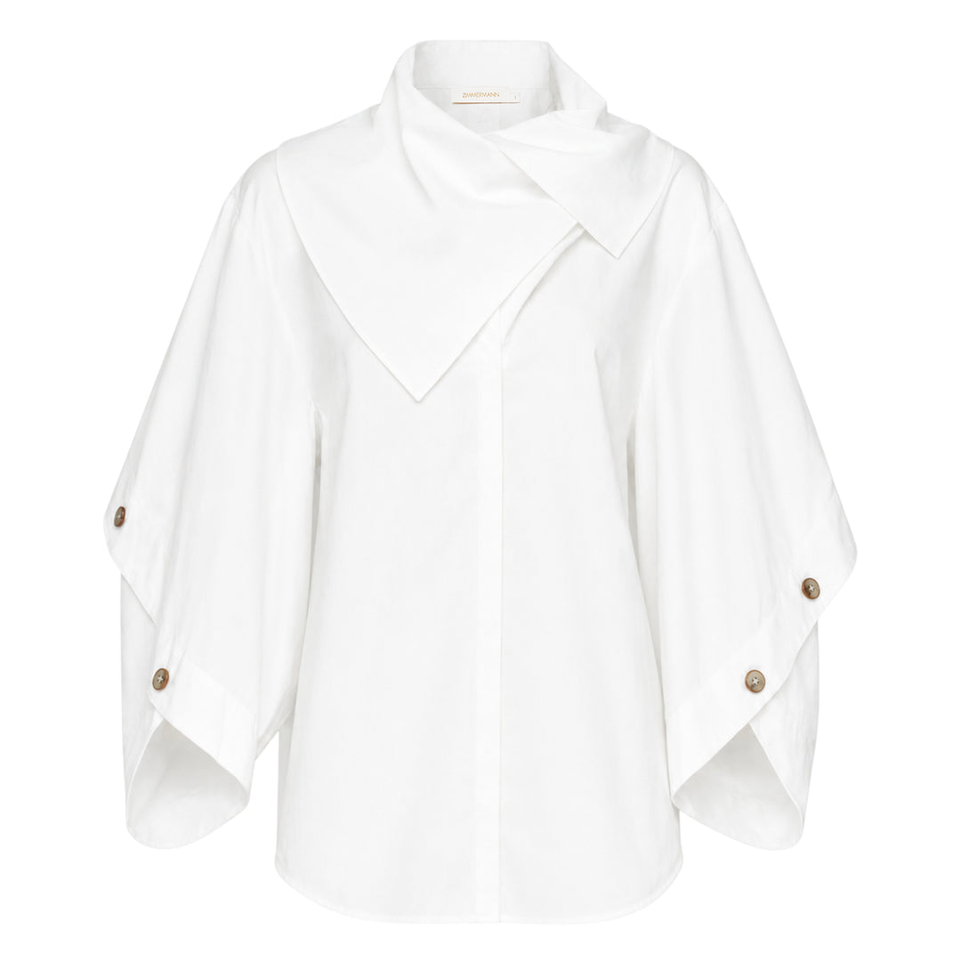 Zimmermann Valiant Utility Shirt in white with sculptural cape sleeves, asymmetric draped collar, and tortoiseshell button cuff detailing