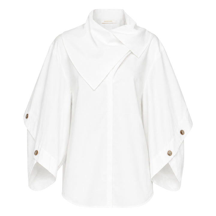 Zimmermann Valiant Utility Shirt in white with sculptural cape sleeves, asymmetric draped collar, and tortoiseshell button cuff detailing