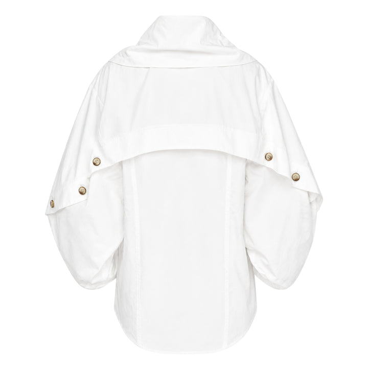 Zimmermann Valiant Utility Shirt in white with sculptural cape sleeves, asymmetric draped collar, and tortoiseshell button cuff detailing