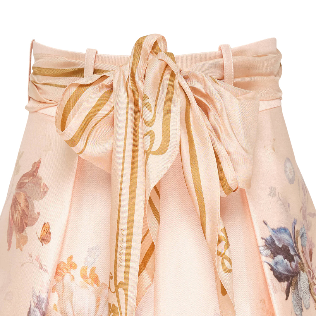Zimmermann Valiant Tuck Shorts in blush pink with an all-over botanical floral print, featuring a full pleated silhouette, high waistband, and a striped sash bow tie at the front