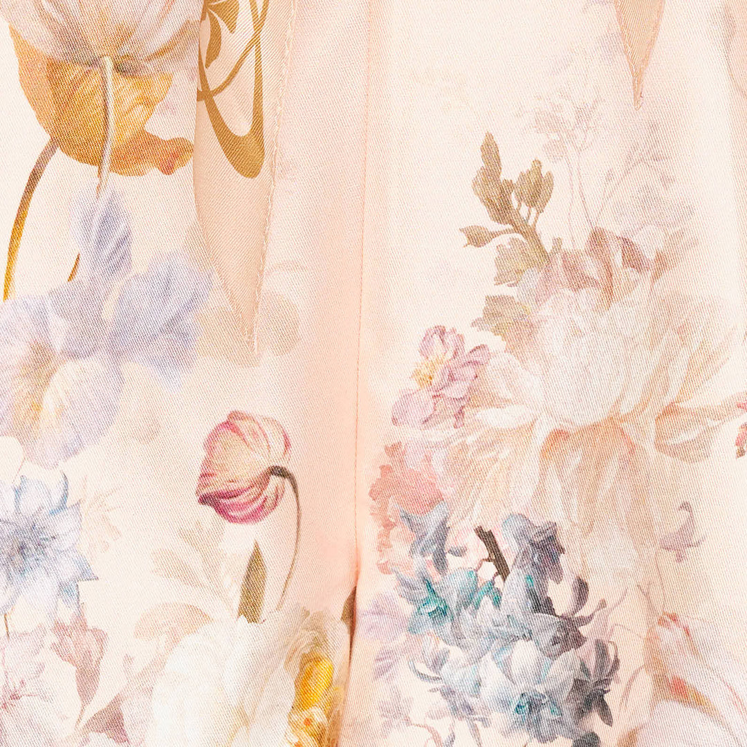 Zimmermann Valiant Tuck Shorts in blush pink with an all-over botanical floral print, featuring a full pleated silhouette, high waistband, and a striped sash bow tie at the front